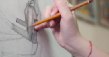 Genç güzel kadın sanatçı bir sanat stüdyosu, bir şövale arkasında oturan ve tuval üzerine resim mevcuttur. Çizim işlemi: sanatçılar sanat stüdyoda el sanat kız ile Canvas.4k bir fırça boyama