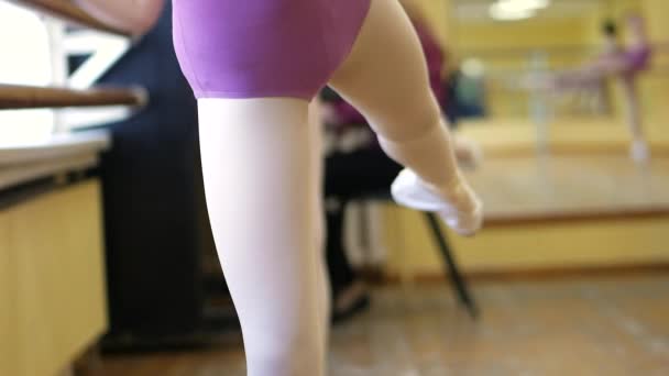 Ballett.Nahaufnahme eines Mädchenbeins in weißen Ballettschuhen beim Balletttraining. Element des klassischen Tanzes. 4k — Stockvideo