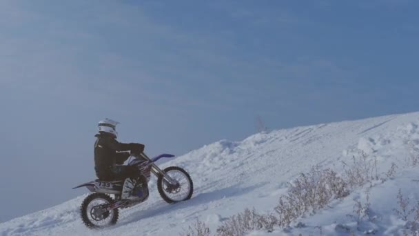 雪に覆われたモトクロス子供自転車ライダーのオートバイを追跡します 雪の上のライダー バイク モトクロス冬シーズンのレースのモトクロス ライダー レーサー バイクに乗って冬の雪に覆われたモトクロス トラック — ストック動画