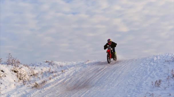 Motocicletas, Crianças motociclistas piloto na pista de motocross nevado. Cavaleiro na neve. Motocross piloto de bicicleta, corrida de inverno de motocross. Passeios de moto Racer em pista de motocross nevado no inverno . — Vídeo de Stock