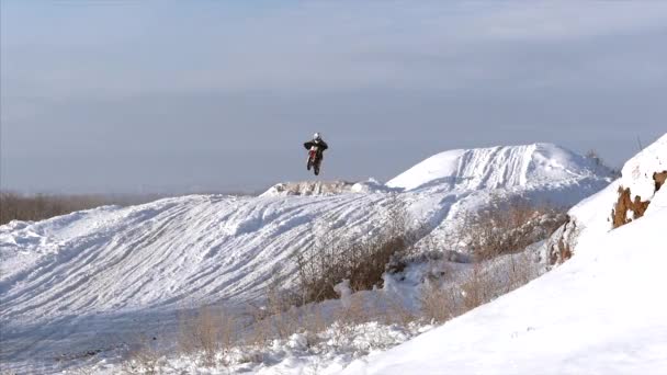 Motorräder, Kinderbiker fahren auf schneebedeckter Motocross-Strecke. Fahrer auf Schnee. Motocross-Fahrer auf dem Fahrrad, Motocross Wintersaisonrennen. Rennmotorrad fährt im Winter auf schneebedeckter Motocross-Strecke. — Stockvideo