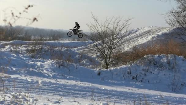 Motorräder, Kinderbiker fahren auf schneebedeckter Motocross-Strecke. Fahrer auf Schnee. Motocross-Fahrer auf dem Fahrrad, Motocross Wintersaisonrennen. Rennmotorrad fährt im Winter auf schneebedeckter Motocross-Strecke. — Stockvideo