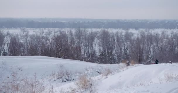 Motorkerékpárok, gyermekek kerékpárosok lovas a havas motocross pálya. Lovas a hó. Motocross versenyző kerékpáros motocross téli szezon versenyen. Motorkerékpár versenyző túrák, a havas motocross pálya télen. — Stock videók