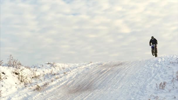 Motocicletas, Crianças motociclistas piloto na pista de motocross nevado. Cavaleiro na neve. Motocross piloto de bicicleta, corrida de inverno de motocross. Passeios de moto Racer em pista de motocross nevado no inverno . — Vídeo de Stock