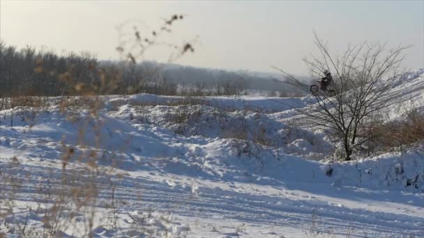 Мотоцикли, дитячі велосипедисти їдуть на сніжній мотокросовій колії. Вершник на снігу. Мотокрос гонщик на велосипеді, мотокрос зимовий сезон гонки. Гонщики на мотоциклі снігова колія взимку . — стокове відео