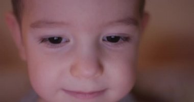 Onun gözlerinde ışık yansıması ile tablet Pc bakarak bir mutlu Childs'ın yüz gece resmi.