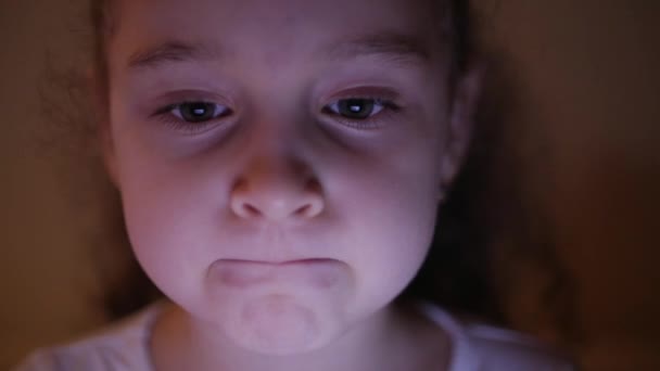 Night Shot of a Cute Caucasian Little Girl Close Up of a Childs Visualizando um PC Tablet com um reflexo da visão e imagens em seus olhos — Vídeo de Stock