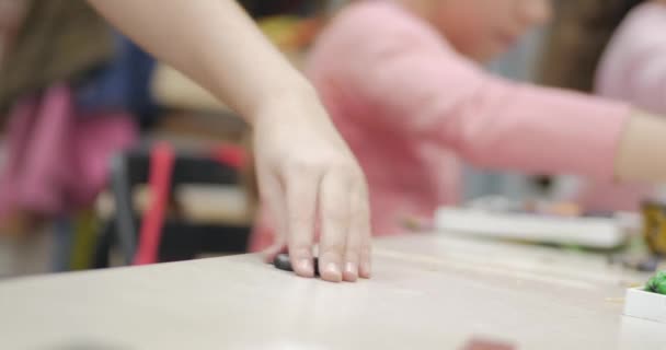 Niedliche kleine Kinder, die am Schreibtisch sitzen, formen aus farbigem Knetmasse im Kinderzimmer eine andere Figur. Entwicklung der Kunst des Modellierens bei Kindern. — Stockvideo