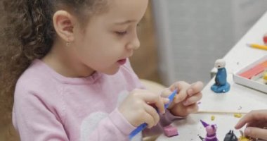 Sevimli küçük çocuklar masa başında oturan Sculpts farklı rakamları renkli modelleme hamuru odasında yapılmış. Modelleme çocuklarda sanatı gelişimi.