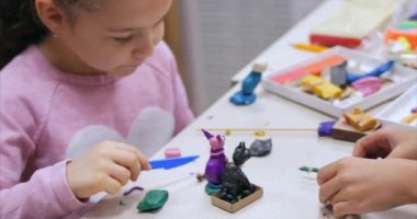 Sevimli küçük çocuklar masa başında oturan Sculpts farklı rakamları renkli modelleme hamuru odasında yapılmış. Modelleme çocuklarda sanatı gelişimi.