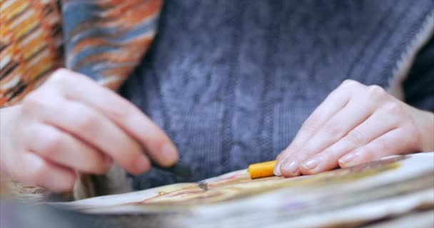 年轻的艺术家之手, 女艺术家画一个画布与石墨铅笔, 坐在一个 ttable 和画的画布。绘画过程: 在艺术家艺术工作室手工女孩素描在罐头食品上。 — 图库视频影像