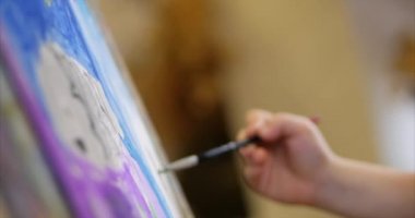Sanatçı, küçük kadın sanatçı genç eller boyalar fırça, oturmuş bir Ttable Çizim tuvaliyle tuval üzerine. Çizim işlemi: sanatçı sanat stüdyosu el kız Canvas.Shot yakın çekim çizimi