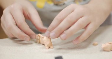 Sevimli küçük çocuklar masa başında oturan Sculpts farklı rakamları renkli modelleme hamuru odasında yapılmış. Modelleme çocuklarda sanatı gelişimi.