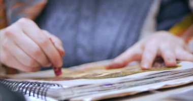 Bir kadın sanatçı bir branda ile Ttable beraberlik oturmuş, bir grafit kalem, boya, sanatçının genç eller yakın çekim çekim tuval üzerine. Çizim işlemi: sanatçı sanat stüdyosu el kadın