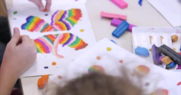 Des petits enfants mignons assis au bureau sculptent des figures différentes à partir de plastique de modélisation coloré dans la pépinière. Développement de l'art de la modélisation chez les enfants . — Video