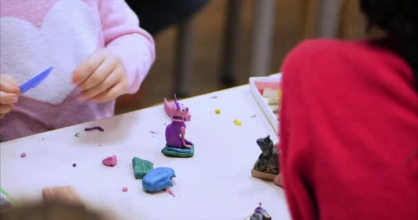 机に座っているかわいい子供たち Sculpts 人影から保育園で色のモデリング粘土製。子供のモデリング技術の開発. — ストック動画