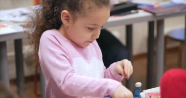 Sevimli küçük çocuklar masa başında oturan Sculpts farklı rakamları renkli modelleme hamuru odasında yapılmış. Modelleme çocuklarda sanatı gelişimi.