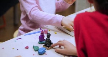 Sevimli küçük çocuklar masa başında oturan Sculpts farklı rakamları renkli modelleme hamuru odasında yapılmış. Modelleme çocuklarda sanatı gelişimi.