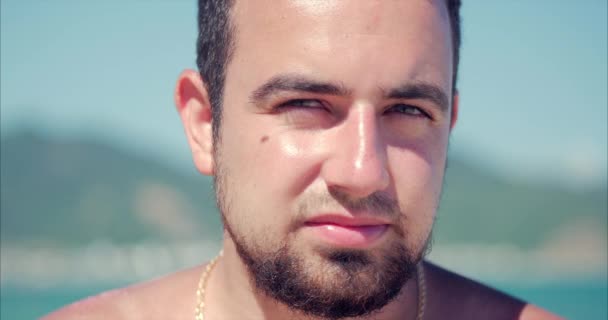 Close Up Portrait Young Caucasian of Handsome Brunette Man a Beard, Looking in the Camera Thoughtful, Smiles Pensive, on Blue Sky Background. — Αρχείο Βίντεο