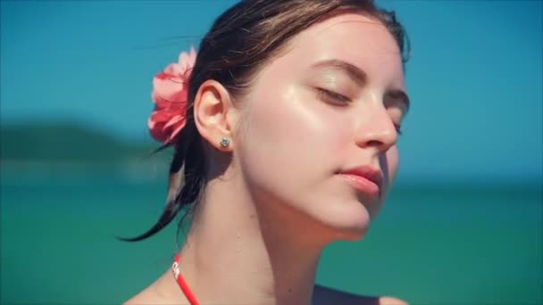 在热带海滩特写镜头的欧洲美丽可爱的褐发女郎在与太阳镜年轻女子或快乐的女孩看着相机, 吹风的风, 缓慢的运动. — 图库视频影像