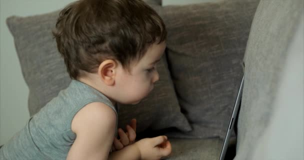 Criança bonito entretendo com Tablet. Little Boy gasta tempo de lazer jogando jogo móvel no e esmaga a tela brilhante com sua mão. Conceito de: Happy Childfood, Tecnologia, Jogos infantis — Vídeo de Stock