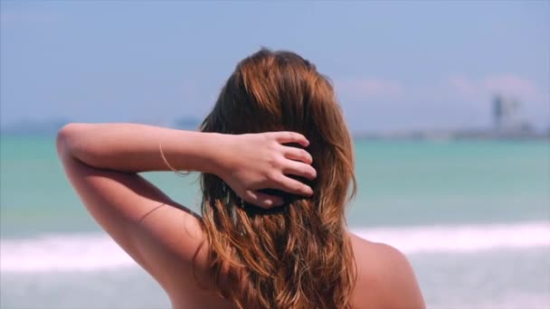 Retrato de cerca de la hermosa morena linda europea Mujer joven o chica alegre mirando hacia el mar, corriendo su mano sobre el cabello soplando en el viento en una playa tropical, cámara lenta . — Vídeos de Stock