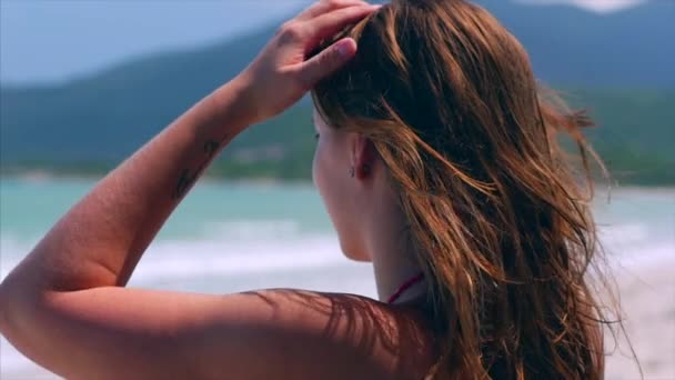 Portret van close up mooie Europese vrouw op het strand kijken naar de zee golven ontspannen door de zee in de zomer. Stock footage. Slow Motion — Stockvideo