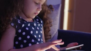 Tablet Ile eğlenceli sevimli çocuk. Küçük kız harcama boş zaman oynamak mobil oyun ve El Ile parlak ekran Hahes. Kavramı: mutlu Childfood, teknoloji, Childen Play