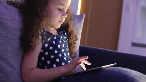 태블릿 재미 귀여운 아이. 어린 소녀에서 모바일 게임을 재생 여가 시간을 보내고 그녀의 손으로 밝은 화면을 분쇄 합니다. 컨셉: 해피 아이 푸드, 테크놀로지, 칠 든 플레이 — 비디오