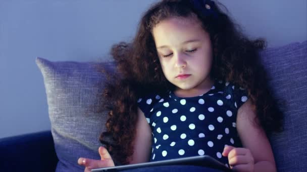 태블릿 재미 귀여운 아이. 어린 소녀에서 모바일 게임을 재생 여가 시간을 보내고 그녀의 손으로 밝은 화면을 분쇄 합니다. 컨셉: 해피 아이 푸드, 테크놀로지, 칠 든 플레이 — 비디오