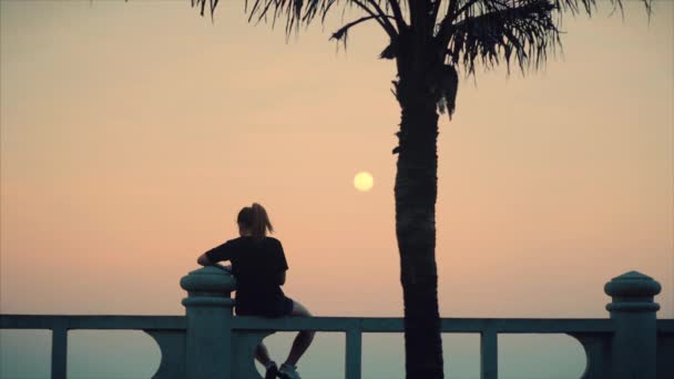 Prachtige Kaukasische vrouw te kijken naar Ocean View bij zonsondergang. Jong mooi meisje genieten van de natuur, kijkend naar de Oceaan, genieten van de kalmte van de natuur genieten van het leven. — Stockvideo