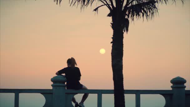 Mulher Caucasiana Maravilhosa Olhando para a Vista do Oceano ao pôr do sol. Menina bonita nova que gosta da natureza, olhando para o oceano, apreciando a calma da natureza que aprecia a vida . — Vídeo de Stock