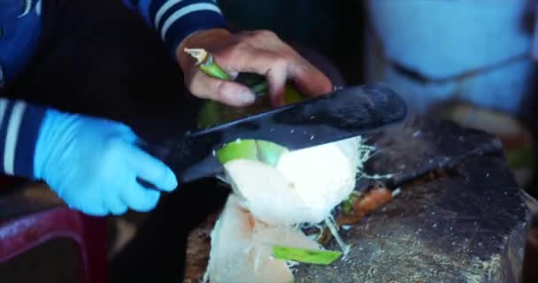 Técnica de limpieza de coco, Manos femeninas machete de coco cortado. La mujer cocina un coco, corta un coco para beberlo. 4K — Vídeo de stock