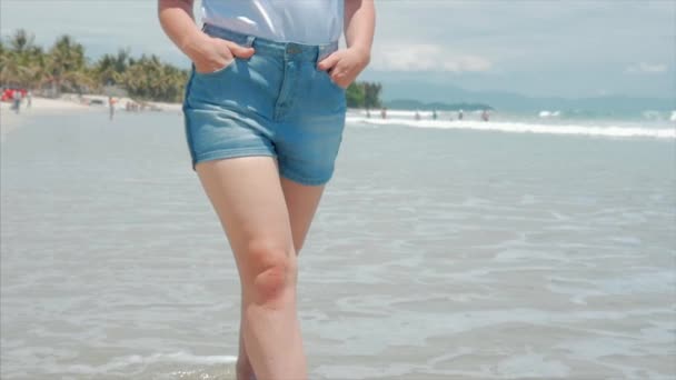 Su una spiaggia tropicale Avvicinamento delle gambe delle donne Europeo Bella Bruna, Passeggiando lungo la spiaggia, Lento movimento . — Video Stock