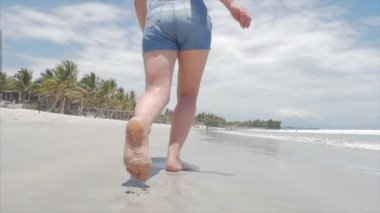 Siyah gözlük, beyaz-gömlek ve mavi şort Avrupa güzel esmer Vietnam tropikal egzotik Sahili boyunca sıcak yaz güneşi altında, okyanus kum sağ çalışan Carefree kız Goes