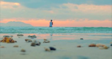 Okyanusta İplik Üzerinde Balık tutan Bir Balıkçının Arka Planında Tropik Lerde Güzel Gün Batımı. Balıkçılar denizde balık tutuyor. Doğa Kavramı, Rahatlama, Rahatlık.