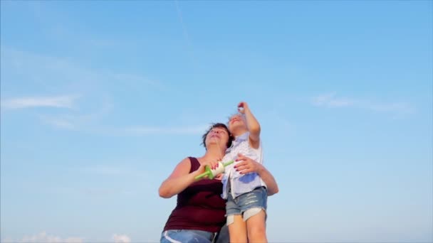 子供と幸せな祖母は、遊んで凧を遊んで、家族は古い凧と遊んで熱帯の海の砂の上を実行します。コンセプト ハッピーで気楽な子供時代. — ストック動画