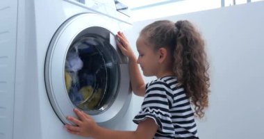 Sevimli Çocuk Çamaşır Makinesi nin İçine Bakıyor. Silindir İplik Makinesi. Konsept Çamaşır Yıkama Makinesi, Sanayi Çamaşırhane Servisi.