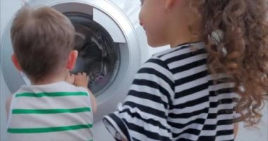 Sevimli Çocuklar Çamaşır Makinesi nin İçine Bakıyor. Silindir İplik Makinesi. Konsept Çamaşır Yıkama Makinesi, Sanayi Çamaşırhane Servisi.