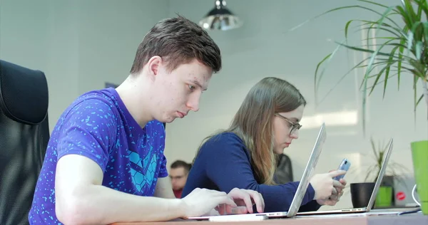 Ofiste Bilgisayar Kullanan Üç Genç İş Adamı. Creative Studio'da Yenilikçi Ürün Tasarımı Üzerine Birlikte Çalışan İki Dekoratör İş Arkadaşı. 4k