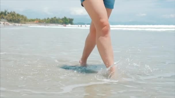 På en tropisk strand närbild av Womens Legs Europeiska vackra brunett, Walking längs stranden, slow motion. — Stockvideo