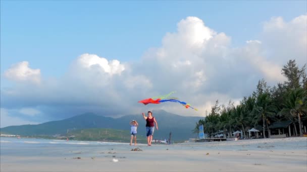 Lycklig mormor med barn att spela flygande kite, familjen körs på sanden i en tropisk Ocean leker med den äldre draken. Concept Happy och bekymmerslös barndom. — Stockvideo