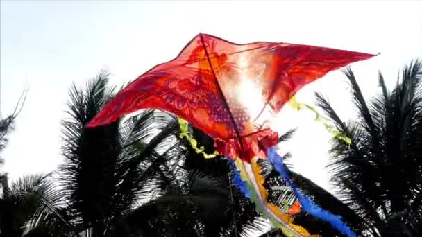 青い空と白い雲と青に対して晴れた日に空を飛ぶ凧のスローモーション映像をクローズアップ. — ストック動画