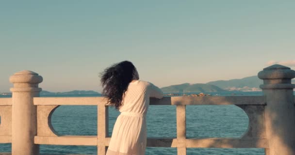 Magnifique femme caucasienne regardant Ocean View au coucher du soleil. Jeune belle fille jouissant de la nature, regardant l'océan, jouissant du calme de la nature jouissant de la vie . — Video