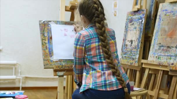 Bambina artista disegna al cavalletto. Processo di disegno: primo piano di pennello e tela . — Video Stock