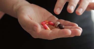 Kadın Eller yakın çekim, Birisi Eline Reçeteli Afyon Pills bir demet döker. Sağlık Kavramı, İlaçlar, Kontrasepsiyon.