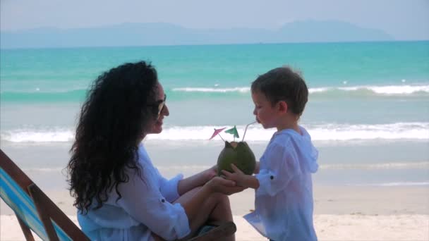 Šťastná matka krmí její roztomilej dítě kokosový. Koncept mamky s dítětem venku, šťastná rodinka, šťastné dětství, děťátko. Koncept svátek, dovolená. — Stock video