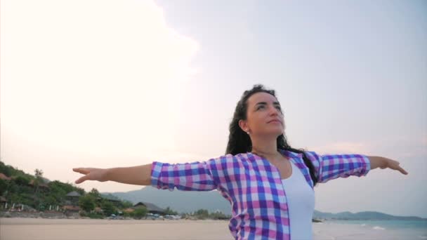 Woman with arms raised On a Tropical Beach Close-Up Portrait of European Beautiful Cute Brunette, Young Woman or Cheerful Girl lifting Arms Up Celebrating Life Scenic Landscape, Blowing Wind Hair the — 비디오