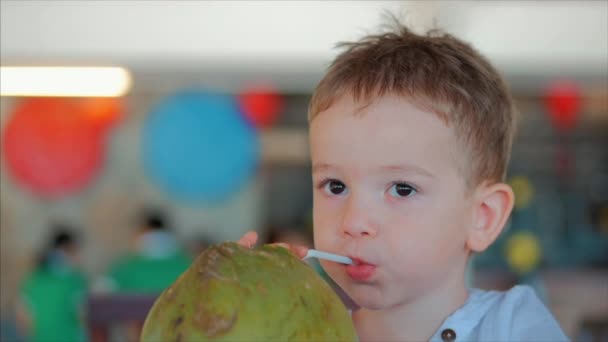 Bambino carino beve una noce di cocco attraverso una cannuccia, primo piano. . Concetto: Bambini, Infanzia felice, Estate, Neonati, Vacanza . — Video Stock