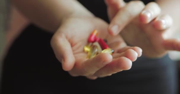 Close-up van vrouwelijke handen, iemand giet een heleboel recept opiaten pillen in de hand. Concept van gezondheid, drugs, anticonceptie. — Stockvideo